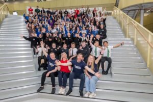 Stemovators 'Construct a Crane' participants, sitting on a staircase, cheering